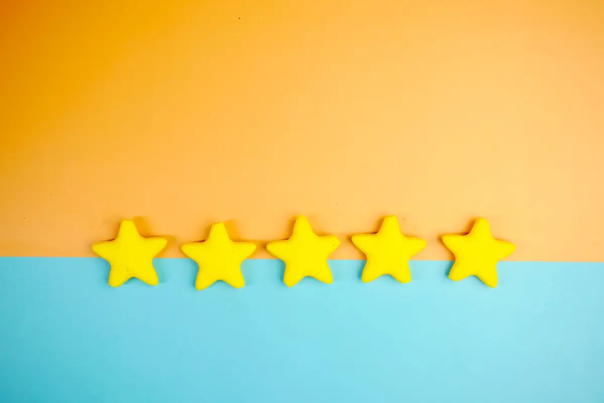 Five yellow stars lined up in a row on a warm orange and blue background